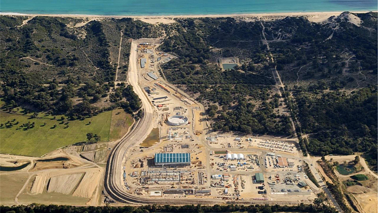 Aerial view of the Southern Seawater Desalination Plant in Perth, showing the desalination facility, processing buildings, pipelines, access roads, and operational infrastructure located between coastal vegetation and the Indian Ocean. 