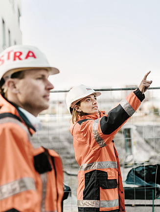 Three construction professionals coordinating work on site, representing safe and reiiable project delivery.