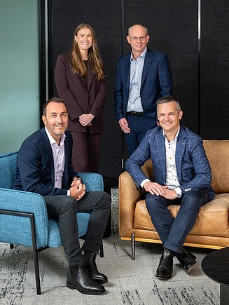 STRABAG Australia Leadership portrait n a modern office environment near floor-to-ceiling windows, wearing business attire.